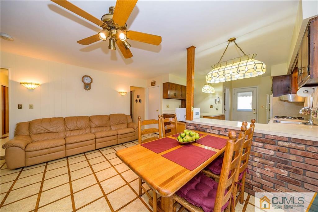 857 Hermann Road North Brunswick, NJ 08902 - Photo 9 of 25 a living room with patio a fireplace and a chandelier