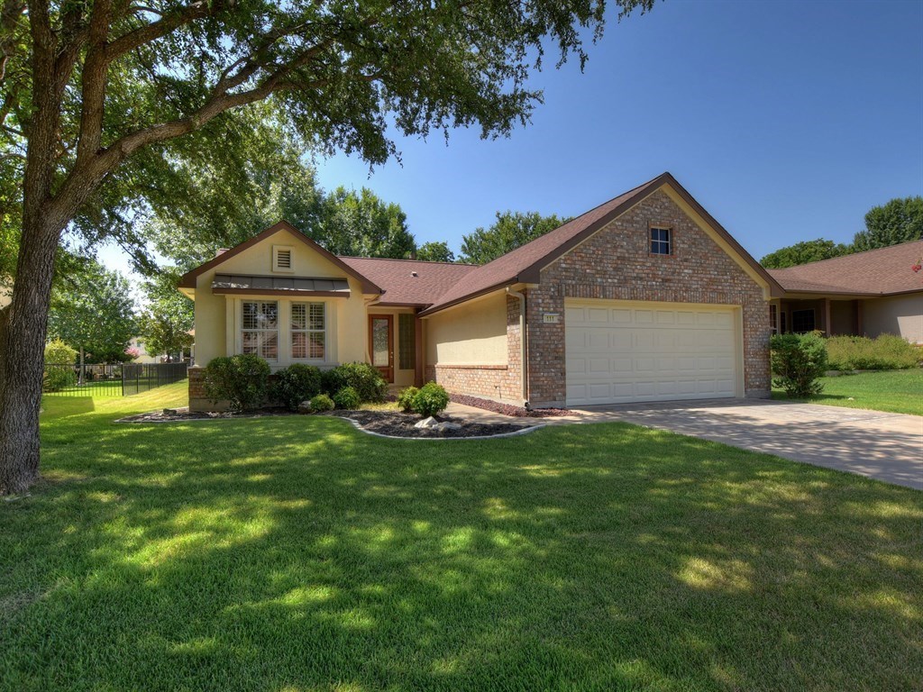 a front view of a house with yard and green space