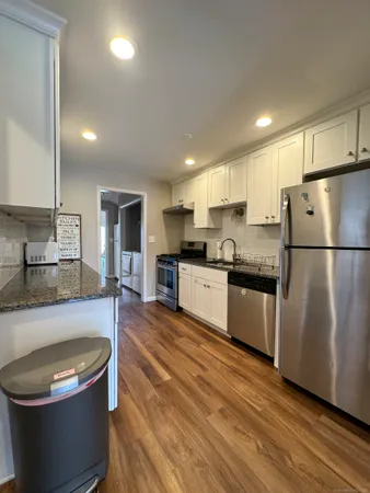 a large kitchen with stainless steel appliances granite countertop a sink a stove a refrigerator a center island and a stove