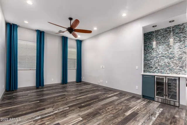 a view of a livingroom with a ceiling fan and wooden floor