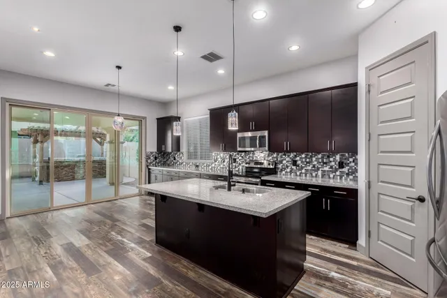 a large kitchen with kitchen island a sink stainless steel appliances and cabinets