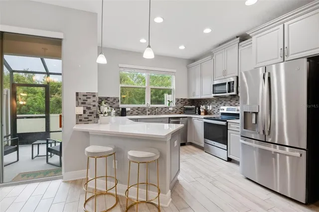 a kitchen with stainless steel appliances a stove a sink refrigerator and cabinets