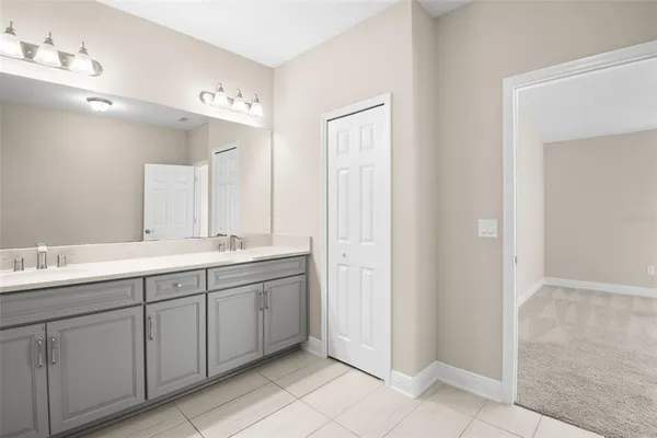 a spacious bathroom with a double vanity sink a mirror and a