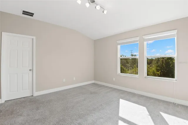 an empty room with windows and closet