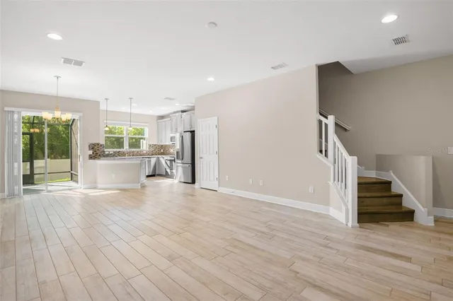 a view of a livingroom with wooden floor and stairs