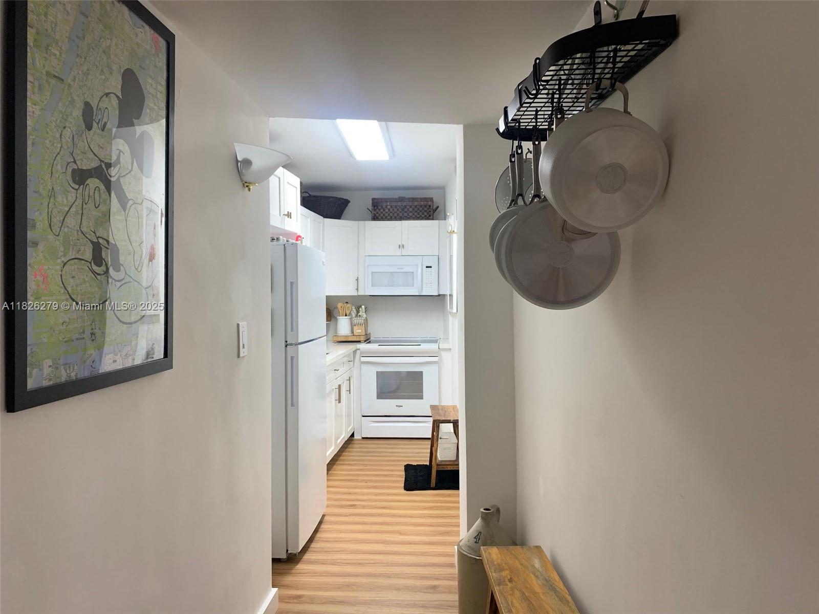 100 Lincoln Road, Unit 315 Miami Beach, FL 33139 - Photo 6 of 16 a kitchen with a refrigerator and cabinets
