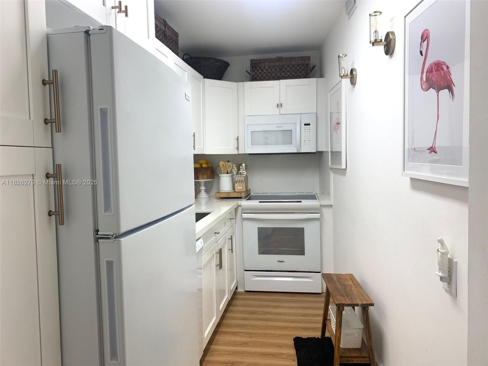 100 Lincoln Road, Unit 315 Miami Beach, FL 33139 - Photo 7 of 16 a kitchen with white cabinets and white appliances