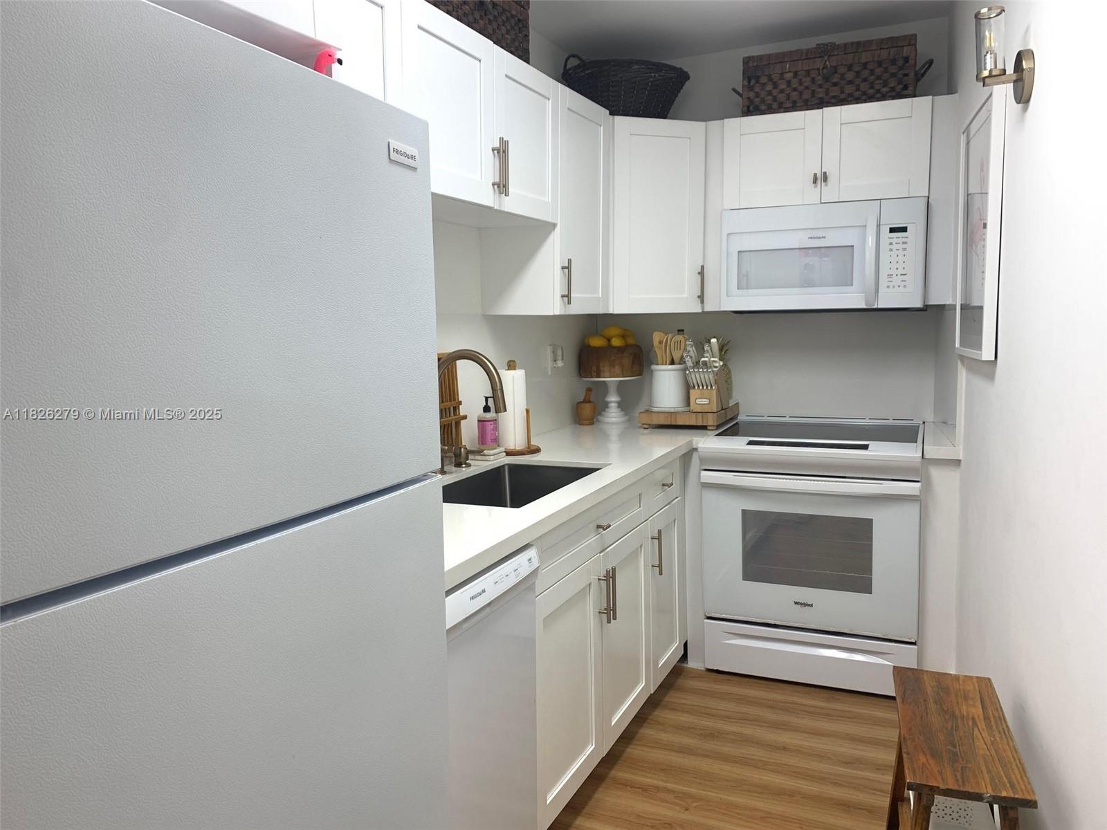 100 Lincoln Road, Unit 315 Miami Beach, FL 33139 - Photo 8 of 16 a kitchen with white cabinets and white appliances