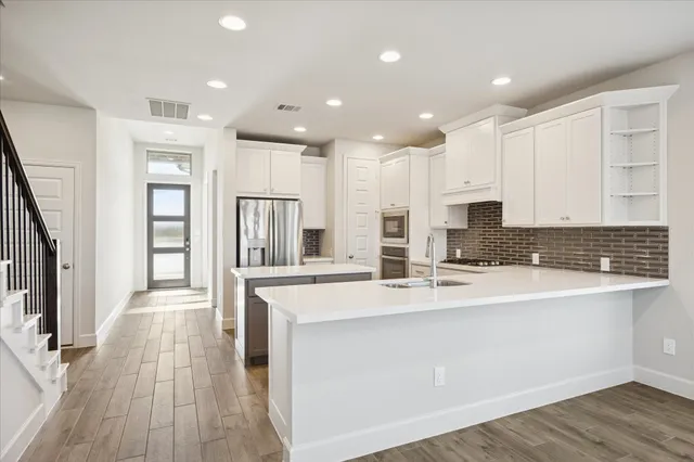 a kitchen with stainless steel appliances granite countertop a sink stove and refrigerator