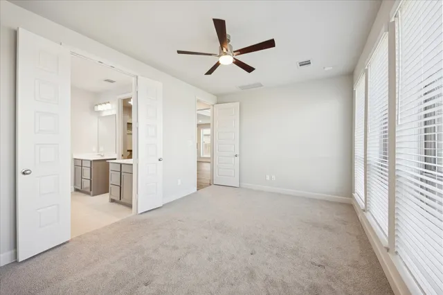 an empty room with fan and windows