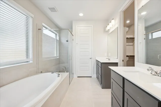 a bathroom with a granite countertop tub sink shower and mirror
