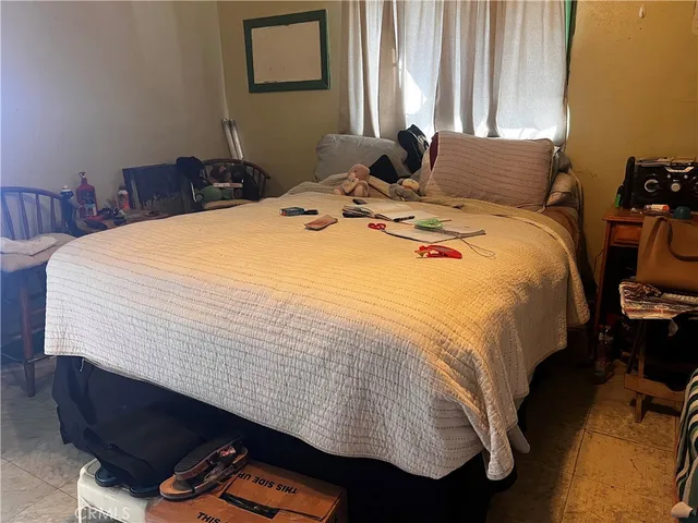 a bed sitting in a bedroom next to a window