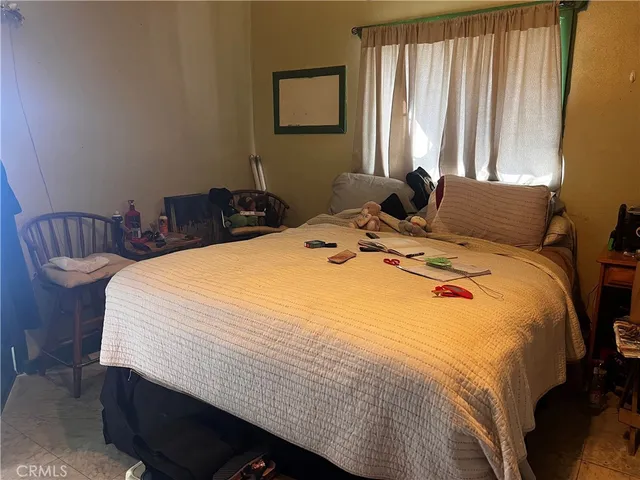 a bed sitting in a bedroom next to a window and a mirror