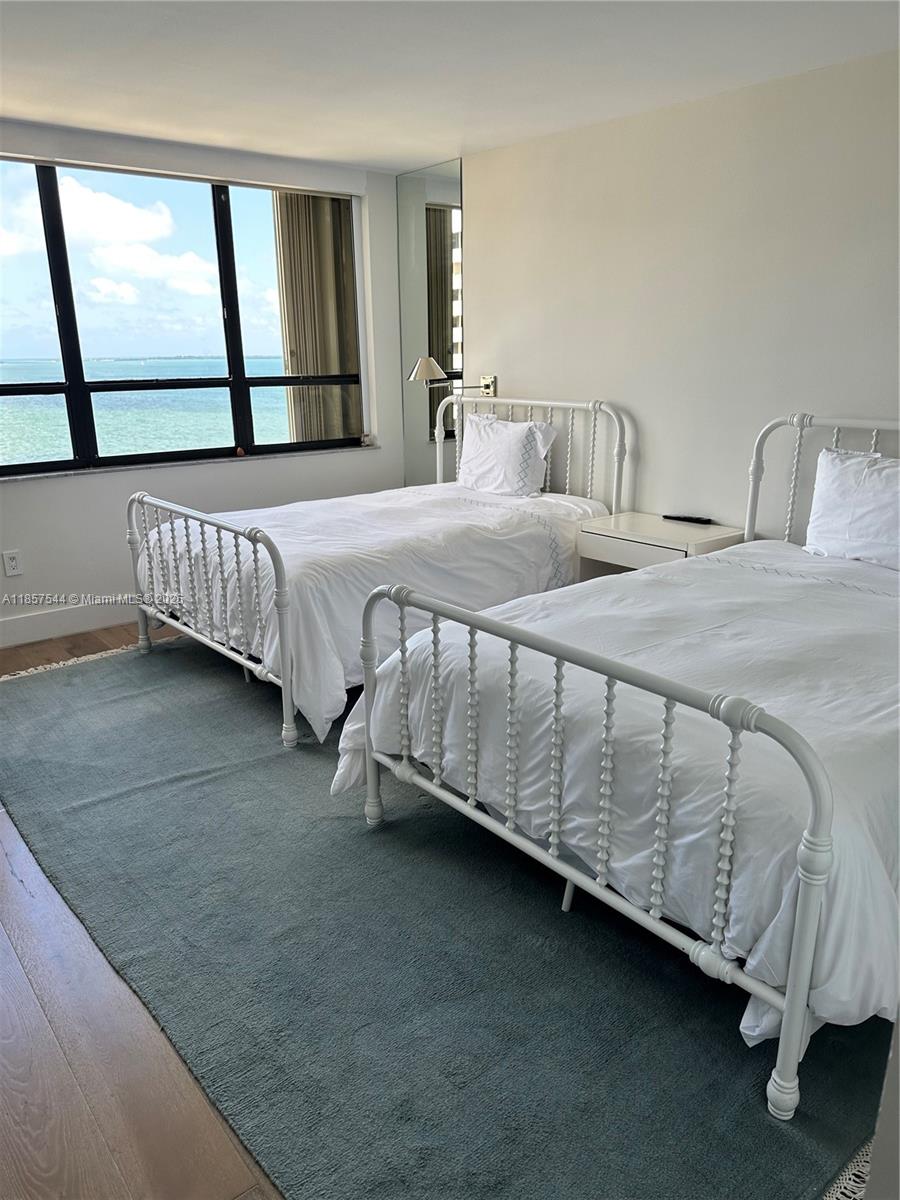 2 Grove Isle Drive, Unit B1501 Miami, FL 33133 - Photo 4 of 17 a bedroom with a bed next to a window