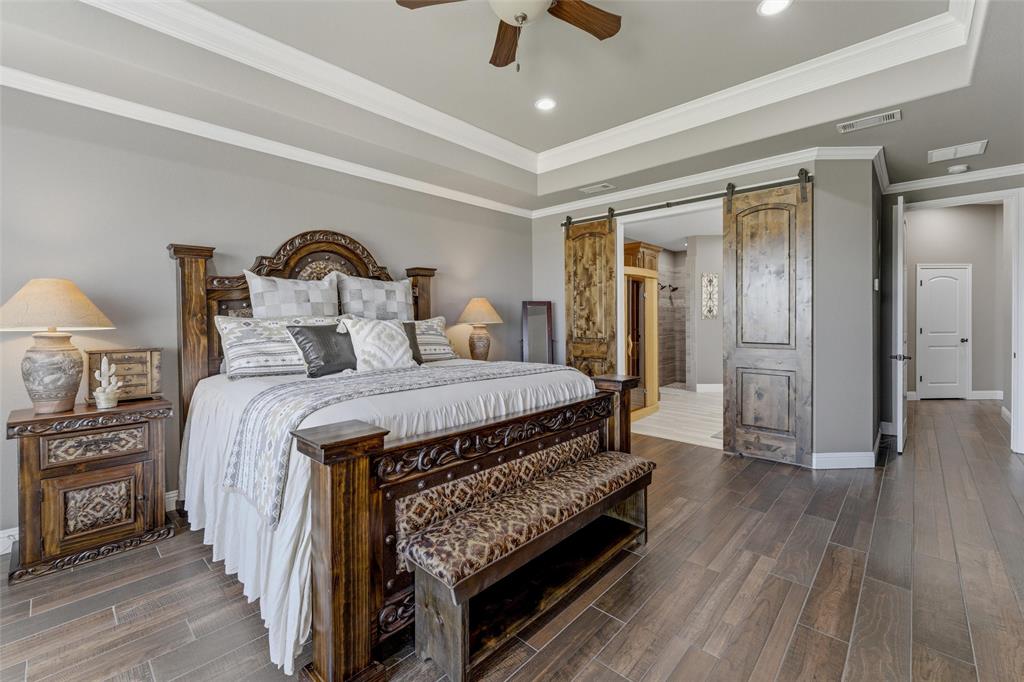 10106 Prather Road Springtown, TX 76082 - Photo 14 of 40 a spacious bedroom with a bed and a chandelier