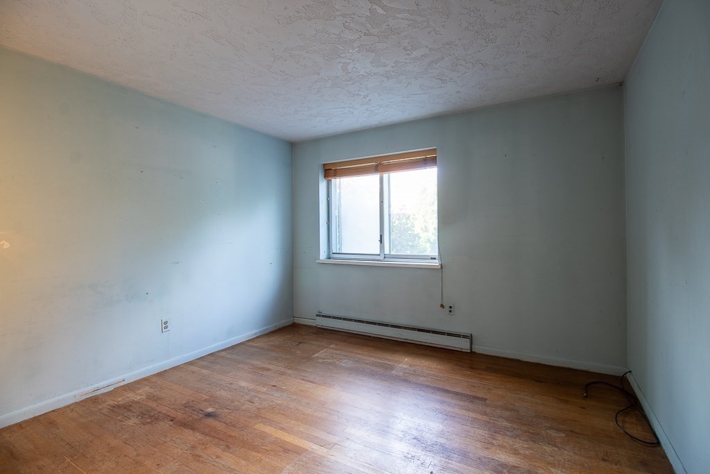 22 Hamilton Road, Unit 206 Arlington, MA 02474 - Photo 12 of 20 an empty room with wooden floor and windows