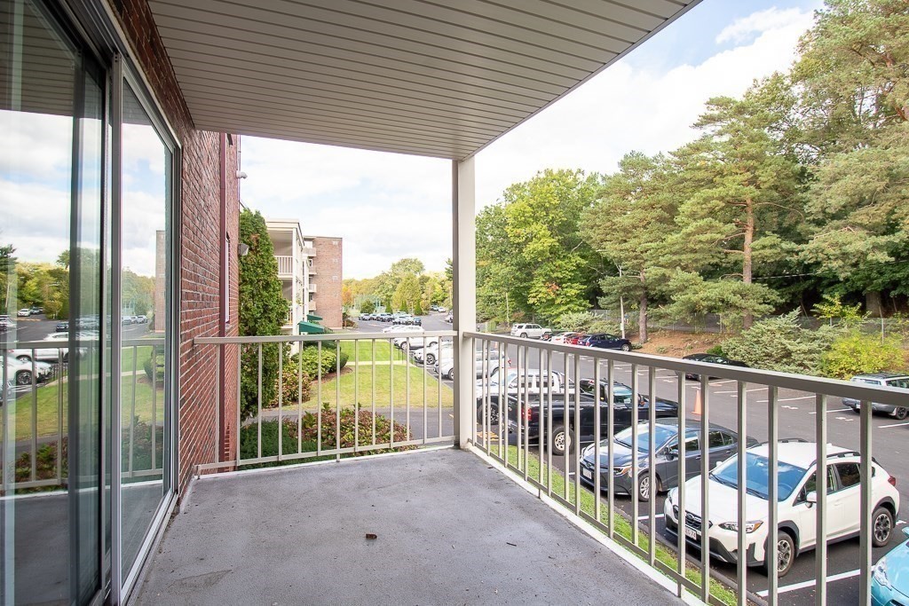 22 Hamilton Road, Unit 206 Arlington, MA 02474 - Photo 16 of 20 a view of a deck with a floor to ceiling window and wooden fence