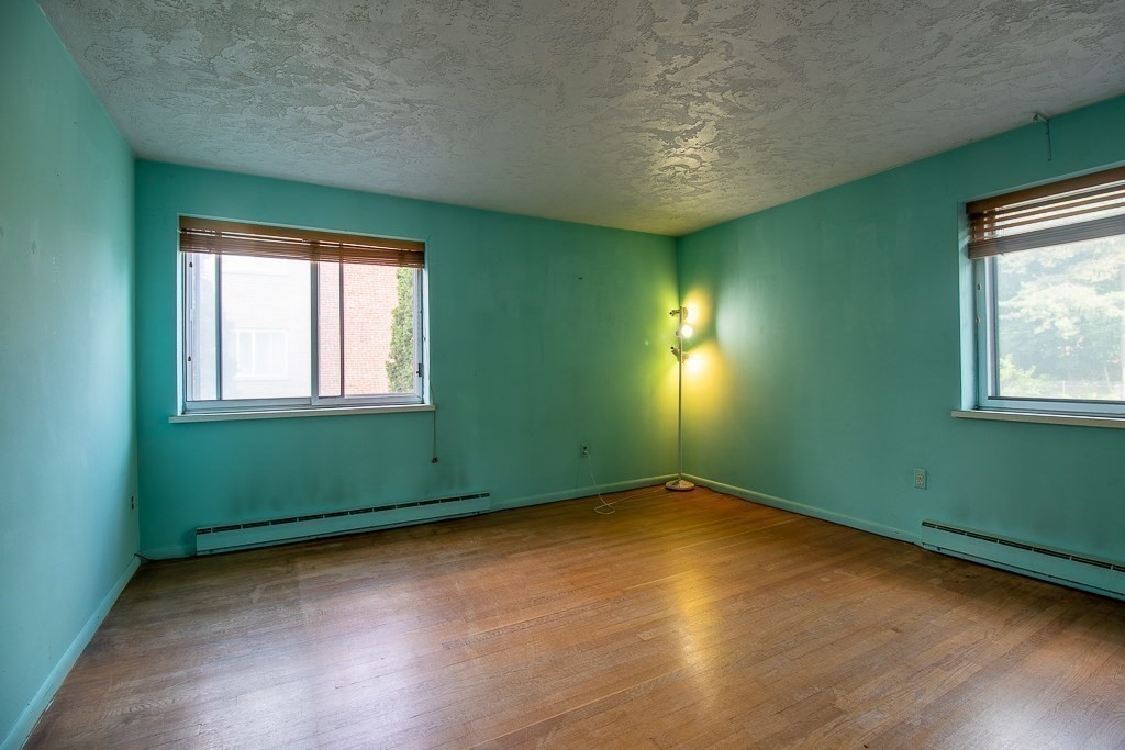 22 Hamilton Road, Unit 206 Arlington, MA 02474 - Photo 17 of 20 an empty room with wooden floor and windows
