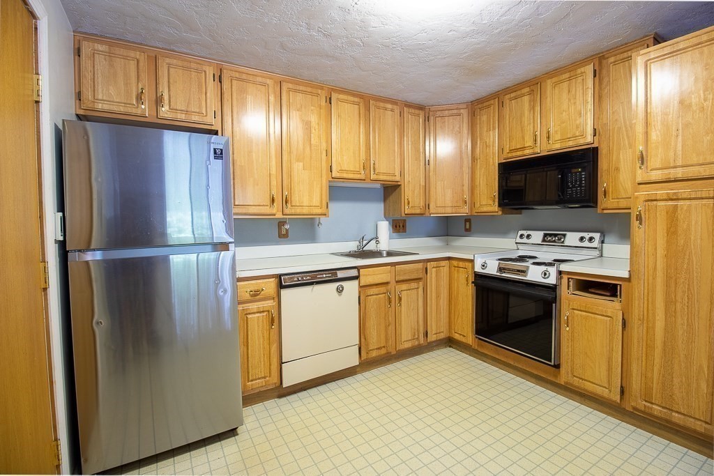 22 Hamilton Road, Unit 206 Arlington, MA 02474 - Photo 5 of 20 a kitchen with stainless steel appliances granite countertop a refrigerator stove and microwave