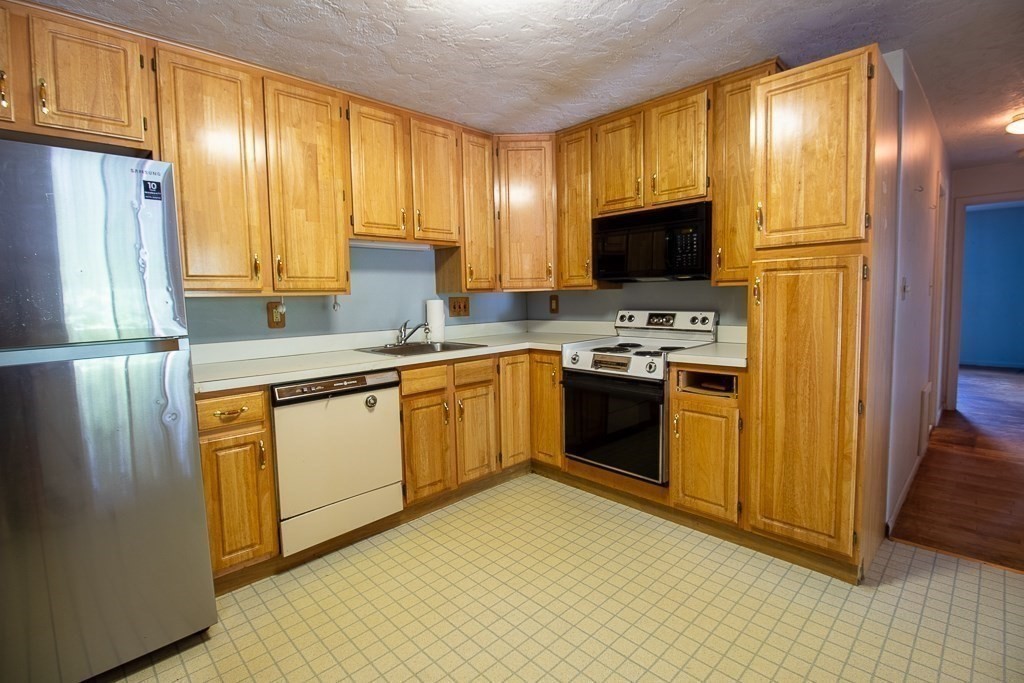 22 Hamilton Road, Unit 206 Arlington, MA 02474 - Photo 6 of 20 a kitchen with stainless steel appliances granite countertop a stove a sink and a refrigerator