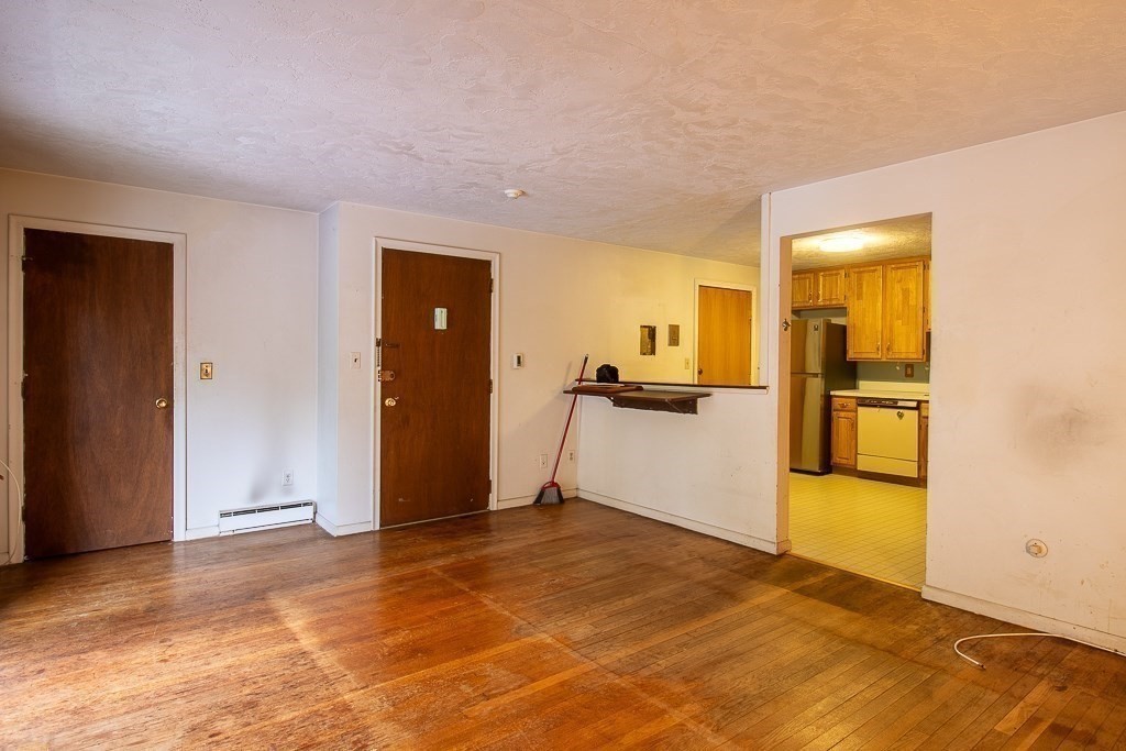 22 Hamilton Road, Unit 206 Arlington, MA 02474 - Photo 10 of 20 a view of a livingroom with wooden floor and a refrigerator