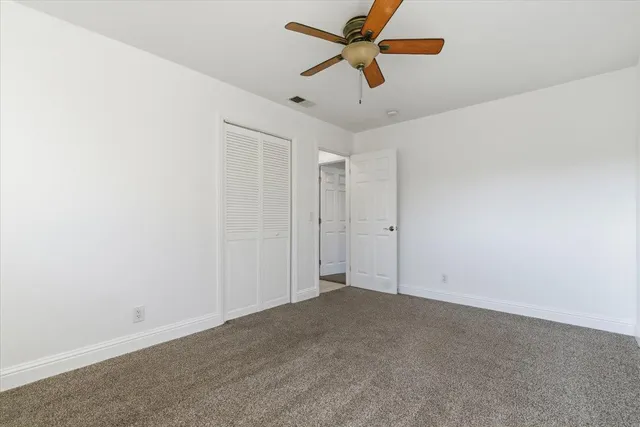 an empty room with a ceiling fan and a fan