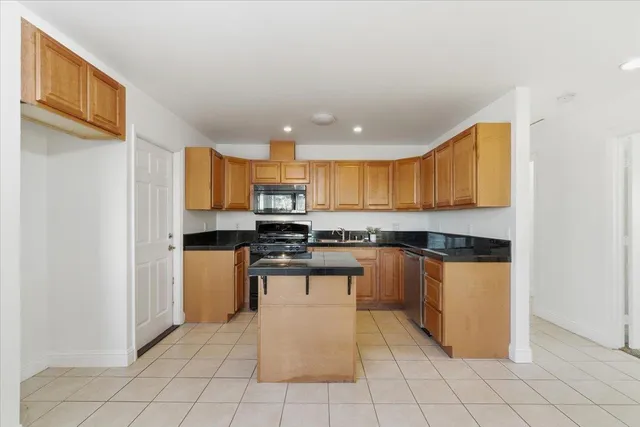 a kitchen with stainless steel appliances granite countertop a refrigerator and a stove top oven