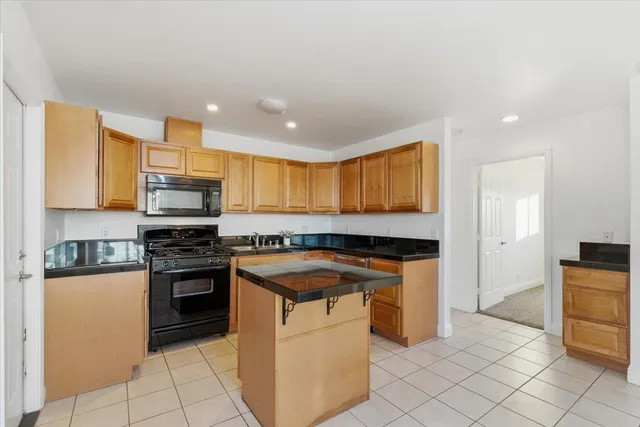 a kitchen with stainless steel appliances granite countertop a stove a sink and a refrigerator