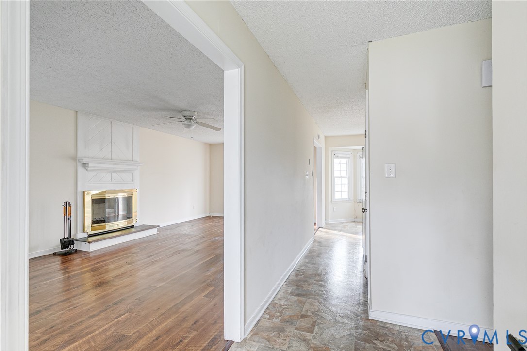 600 Queensway Road Chesterfield, VA 23236 - Photo 13 of 33 a view of a hallway with wooden floor a kitchen space with refrigerator and windows