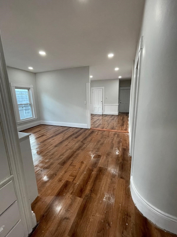 176 Broadway, Unit 2 Methuen, MA 01844 - Photo 4 of 8 a view of an empty room and window and wooden floor