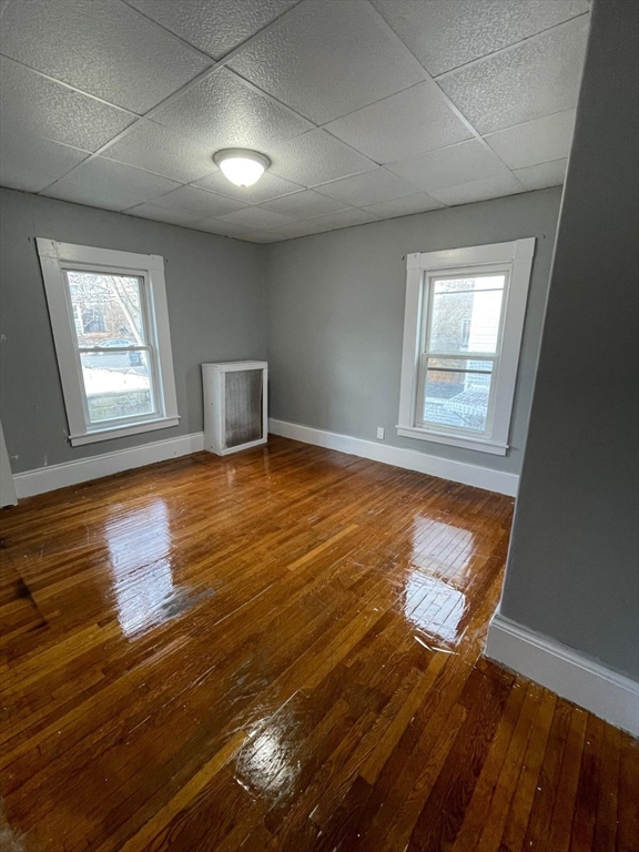 176 Broadway, Unit 2 Methuen, MA 01844 - Photo 5 of 8 an empty room with wooden floor and windows