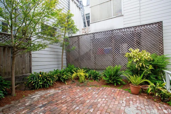 a view of a house with potted plants and a bench