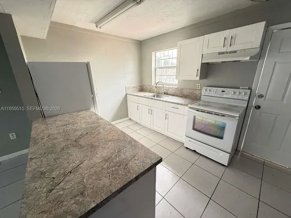 a kitchen with granite countertop cabinets stainless steel appliances and a sink