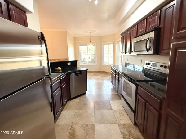 a kitchen with stainless steel appliances granite countertop a refrigerator a stove a sink and dishwasher