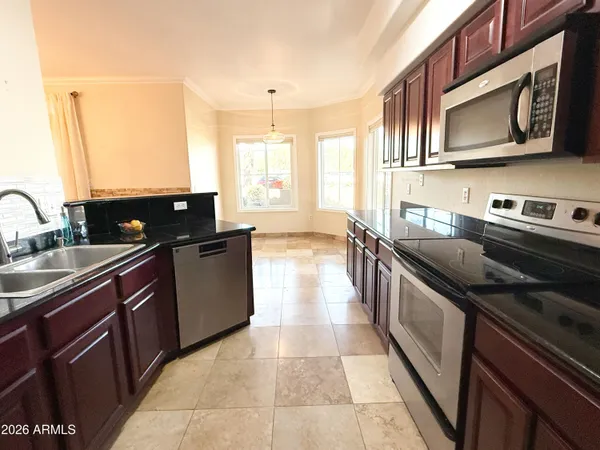 a kitchen with stainless steel appliances granite countertop a sink stove and microwave