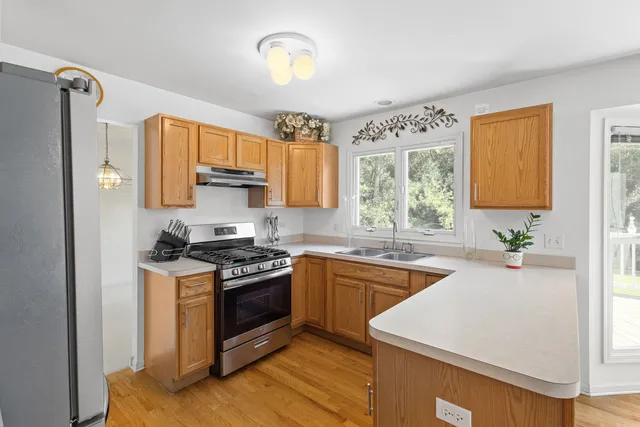 a kitchen with stainless steel appliances granite countertop a stove a sink and a refrigerator