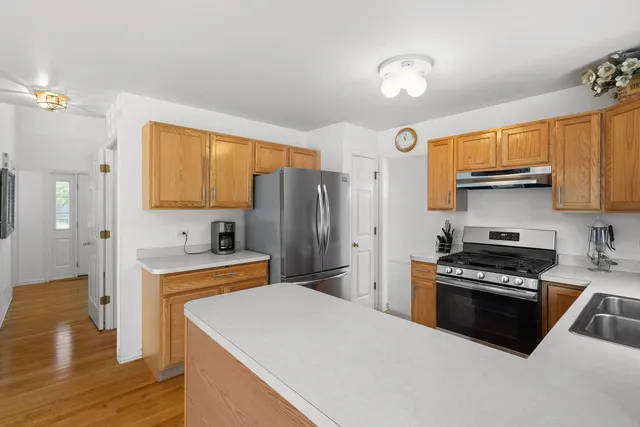 a kitchen with stainless steel appliances a stove refrigerator sink and cabinets