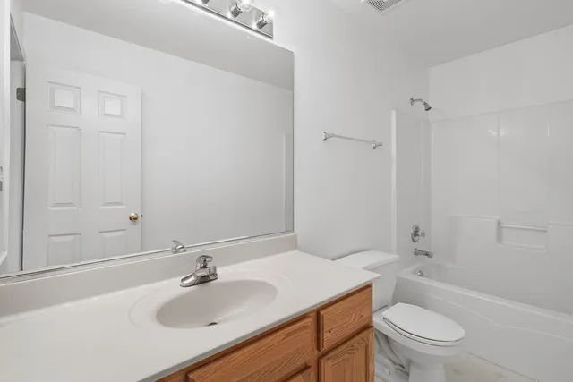 a bathroom with a sink toilet vanity and shower