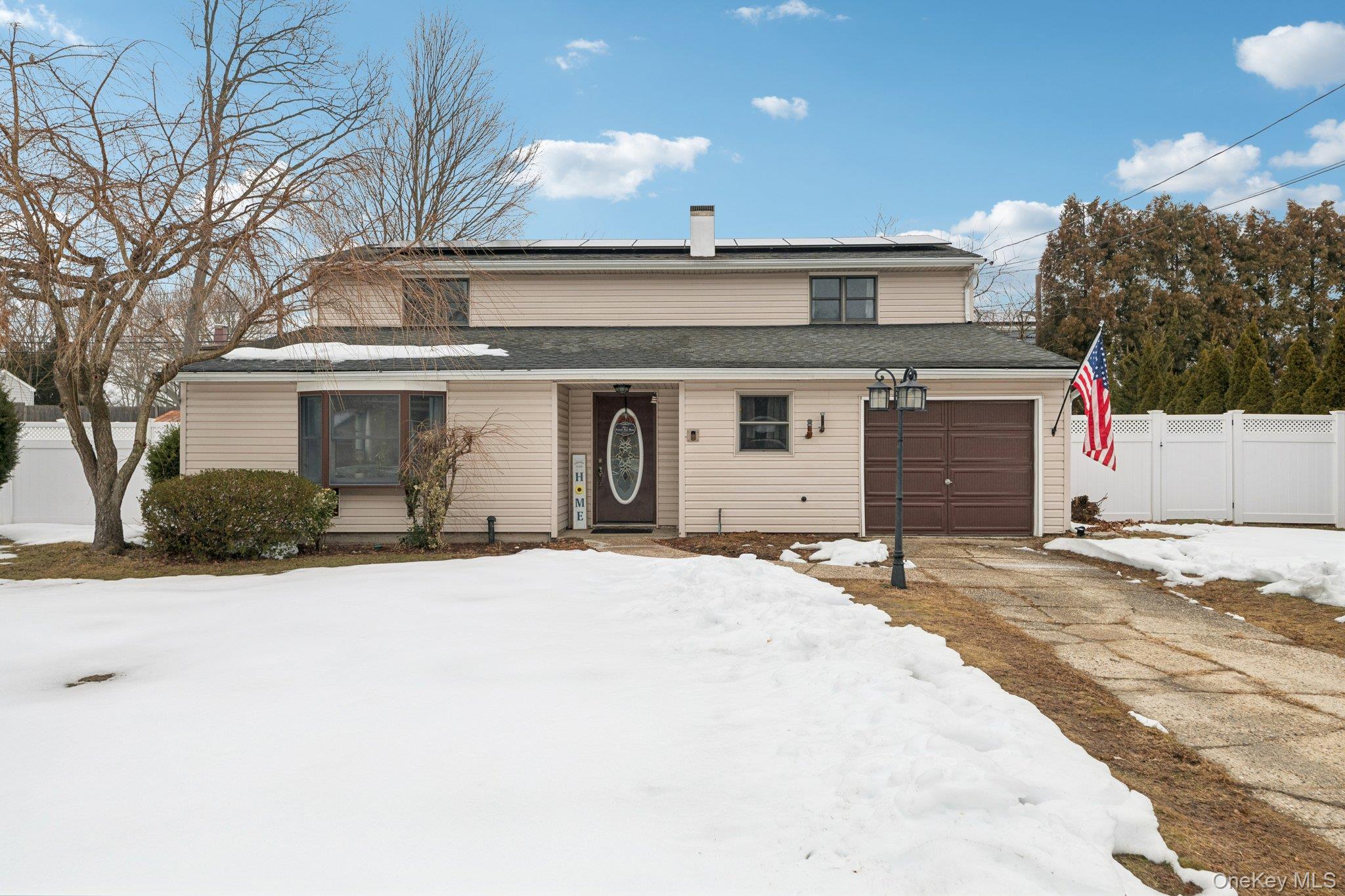25 Wilson Street Centereach, NY 11720 - Photo 1 of 27 a front view of a house with a yard and garage