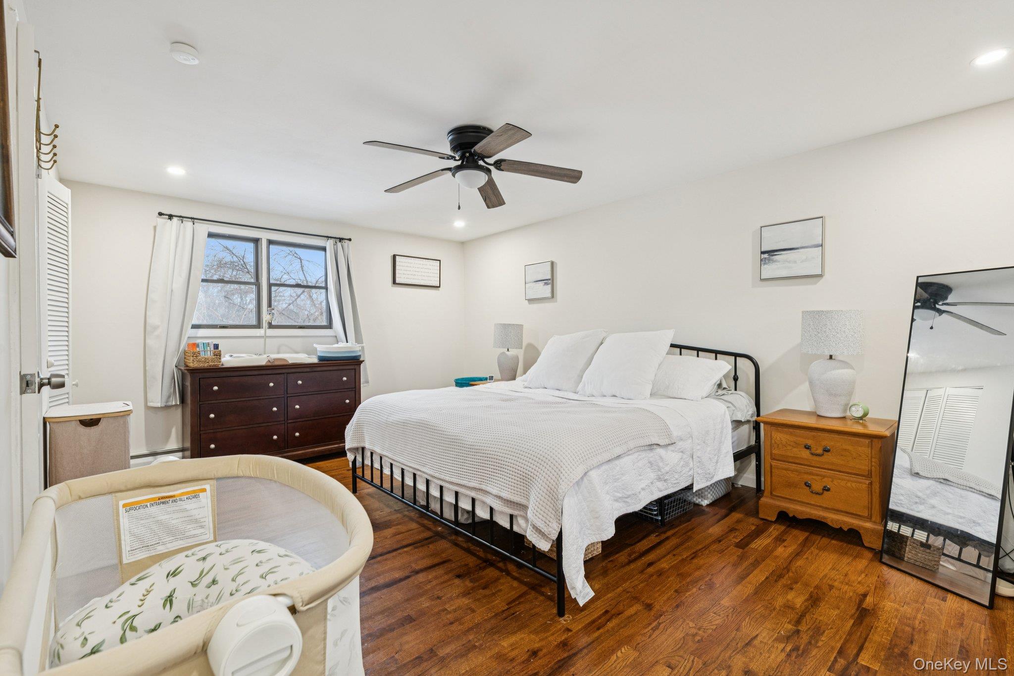 25 Wilson Street Centereach, NY 11720 - Photo 16 of 27 a bedroom with a bed and wooden floor