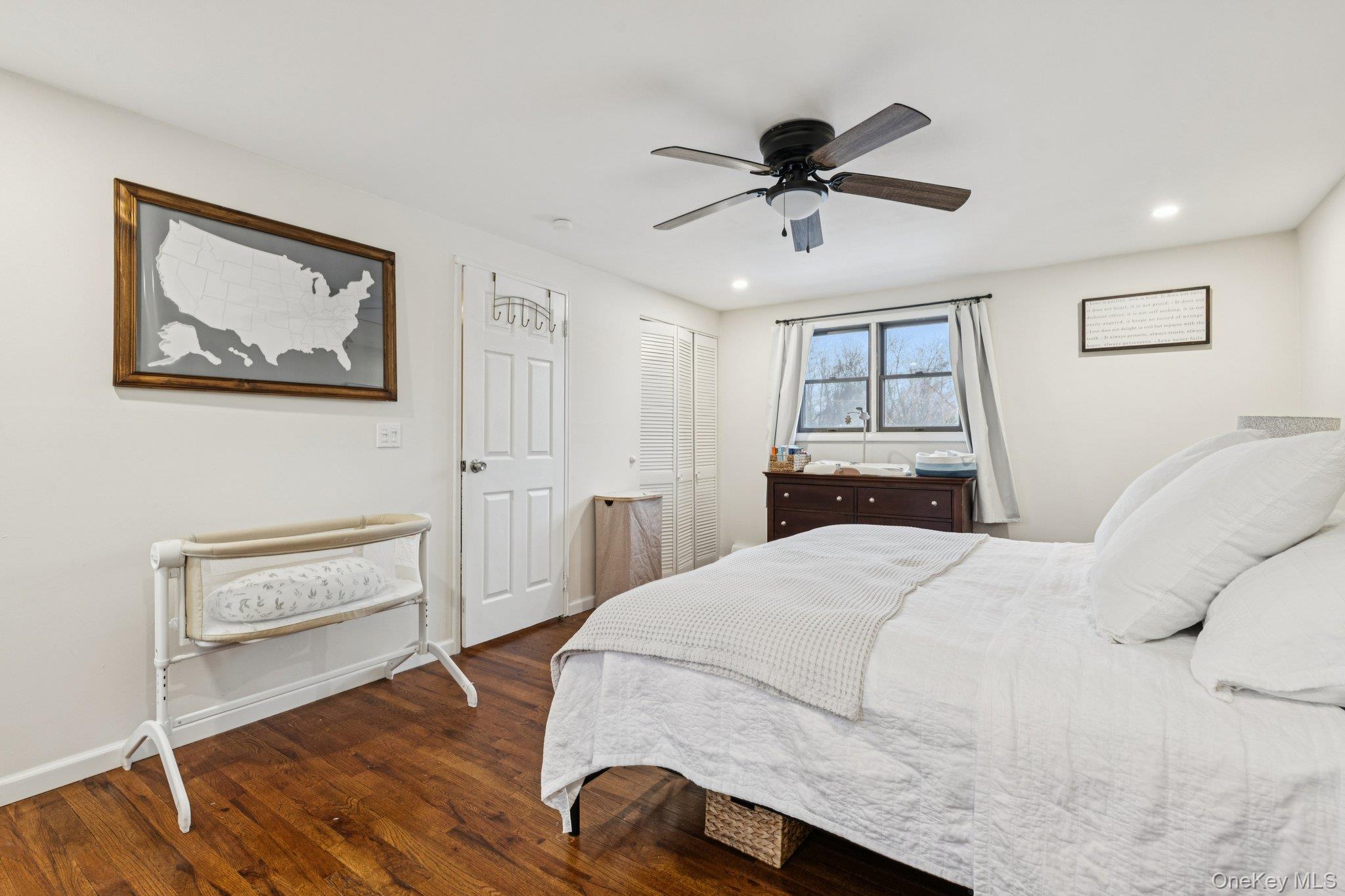 25 Wilson Street Centereach, NY 11720 - Photo 18 of 27 a bedroom with a bed and a chandelier