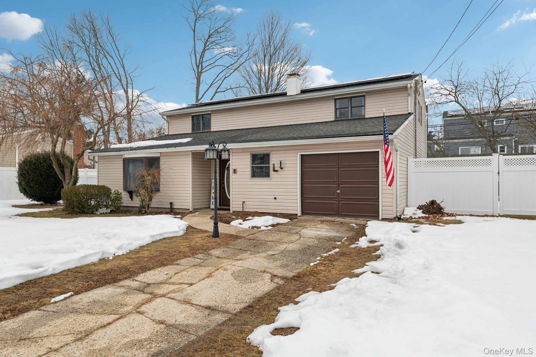 25 Wilson Street Centereach, NY 11720 - Photo 2 of 27 a front view of a house with a yard and garage