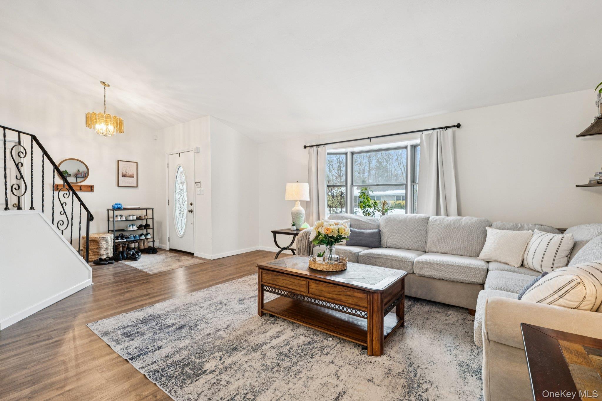 25 Wilson Street Centereach, NY 11720 - Photo 6 of 27 a living room with furniture and a table with wooden floor