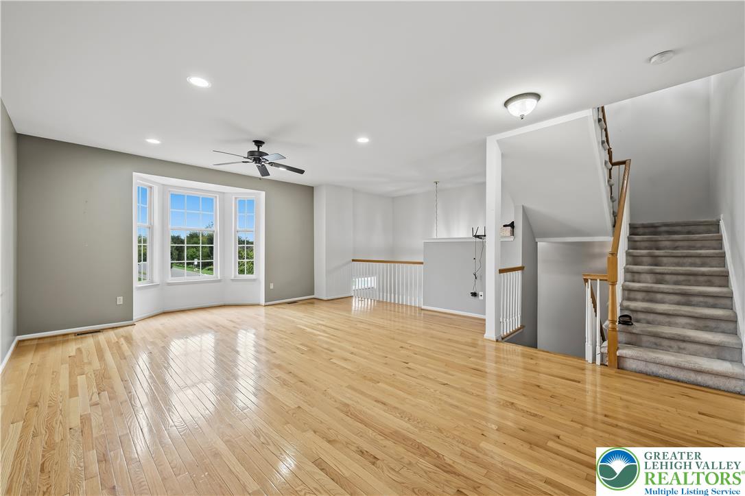 5607 Spring Ridge Drive West Macungie, PA 18062 - Photo 6 of 26 Polished hardwood floors and a bright bay window define this versatile open living space.
