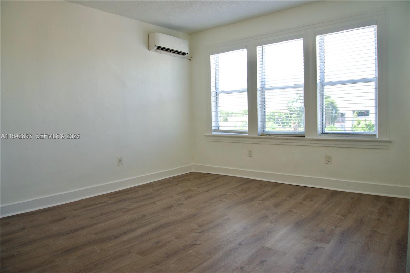 501 Southwest 6th Court, Unit 214 Miami, FL 33130 - Photo 1 of 30 an empty room with wooden floor and windows