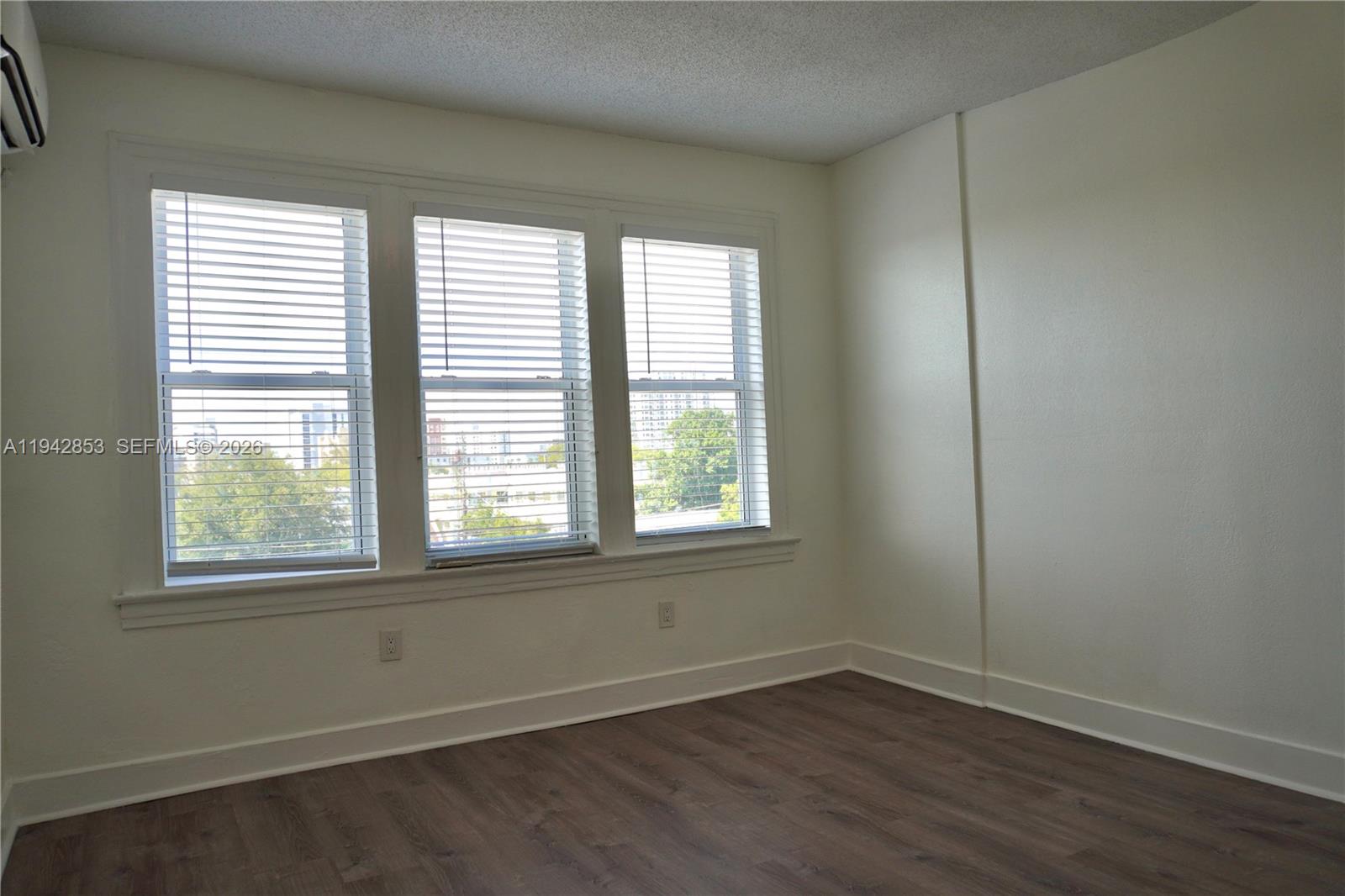 501 Southwest 6th Court, Unit 214 Miami, FL 33130 - Photo 4 of 30 an empty room with wooden floor and windows