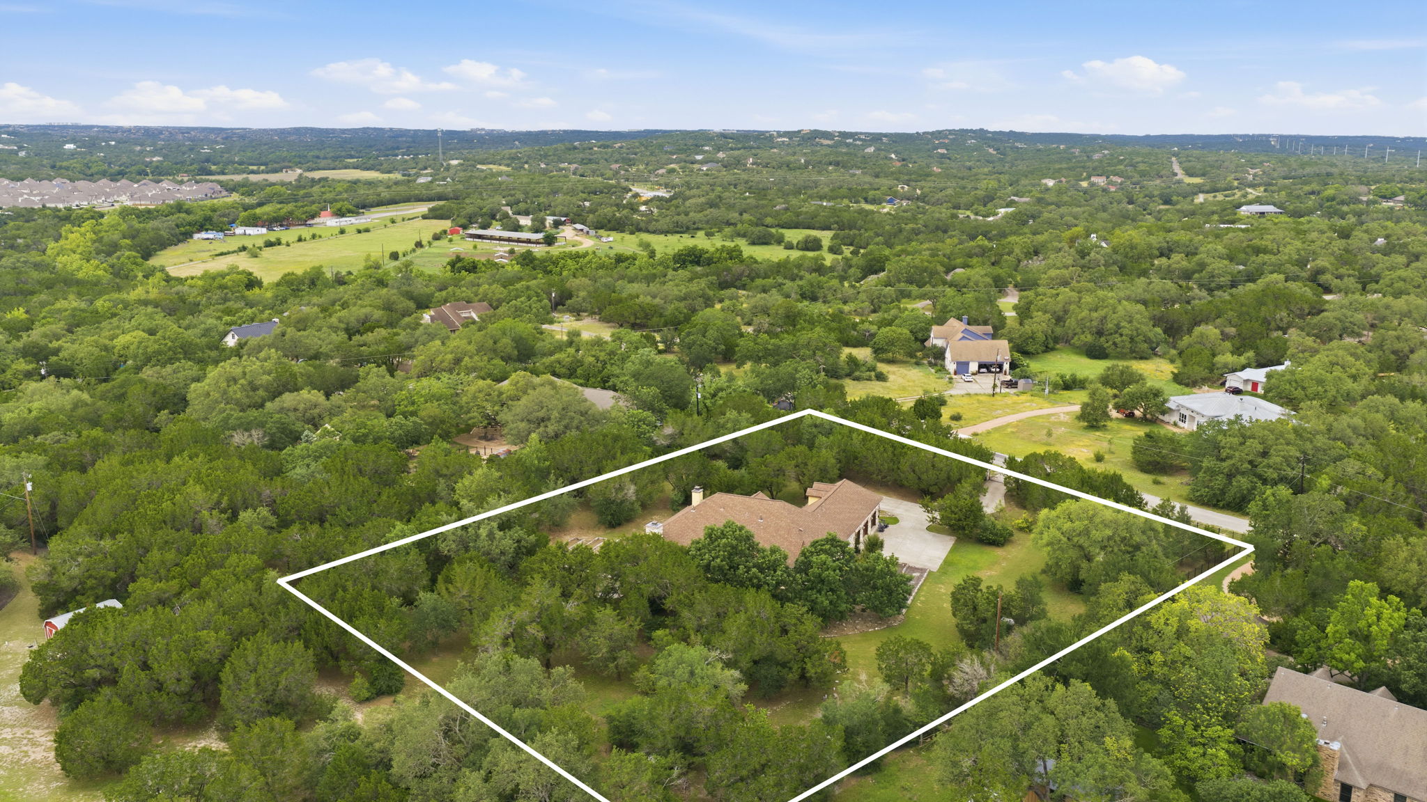 8121 Bluff Trail Austin, TX 78737 - Photo 37 of 40 An aerial perspective showcases a generously sized property nestled amidst dense, mature tree cover.