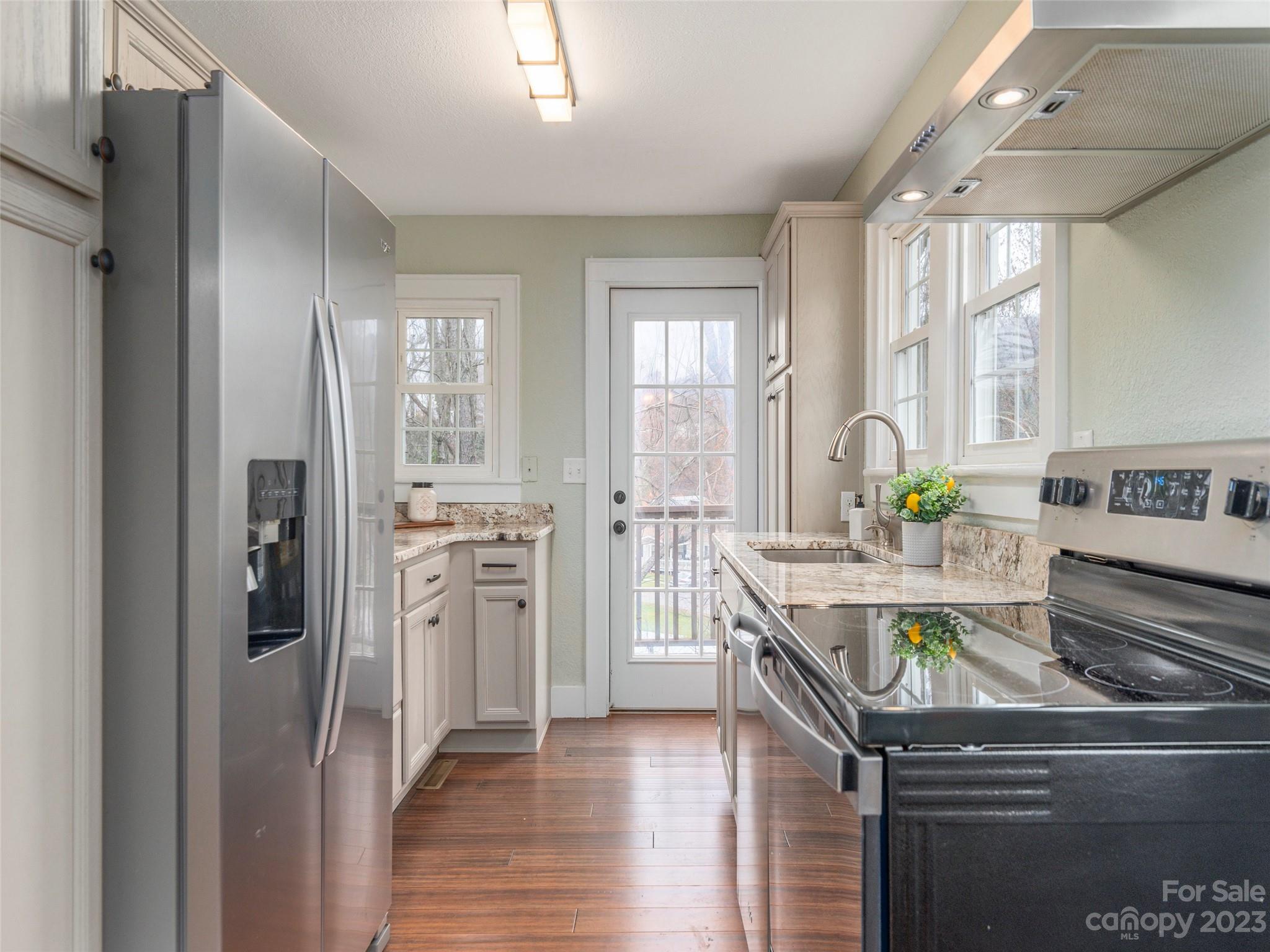 2117 Old Clyde Road Clyde, NC 28721 - Photo 12 of 24 a kitchen with white cabinets and stainless steel appliances