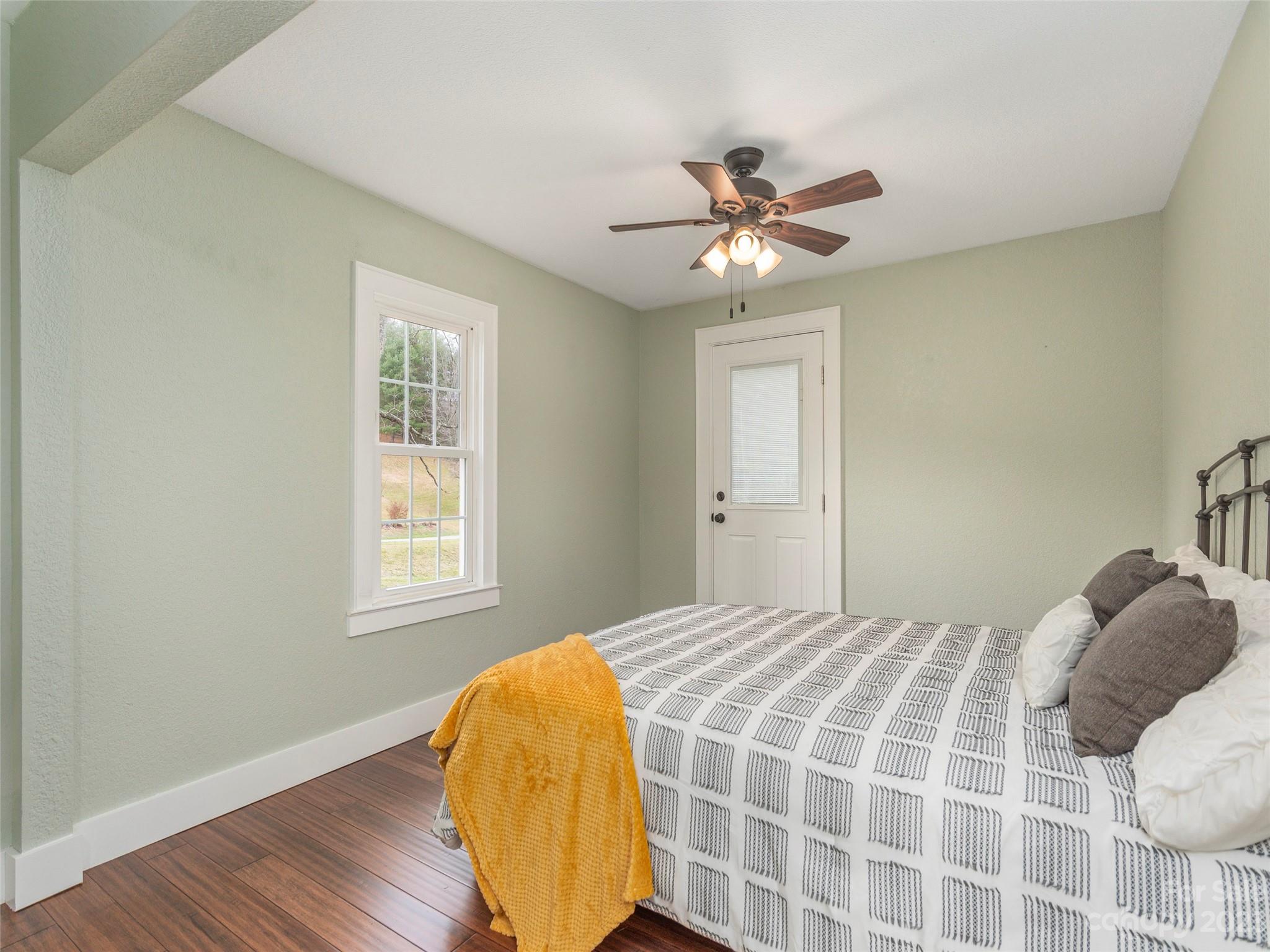 2117 Old Clyde Road Clyde, NC 28721 - Photo 15 of 24 a bedroom with a bed and wooden floor