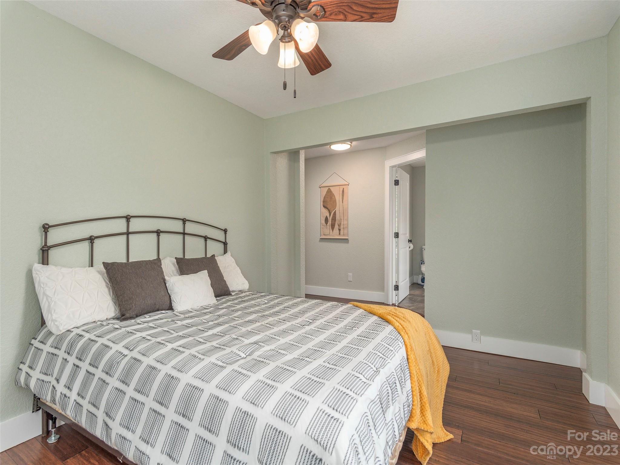 2117 Old Clyde Road Clyde, NC 28721 - Photo 4 of 24 a bedroom with a large bed and a chandelier